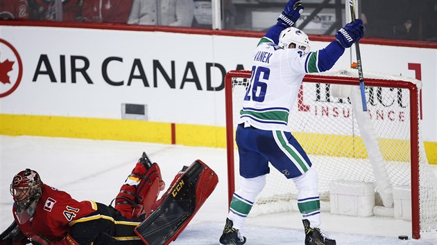 Thomas Vanek z Vancouveru js, brank Calgary Mike Smith le pokoen na led.