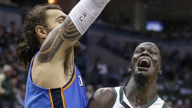 Steven Adams (vlevo) z Oklahoma City brzd Thona Makera z Milwaukee.