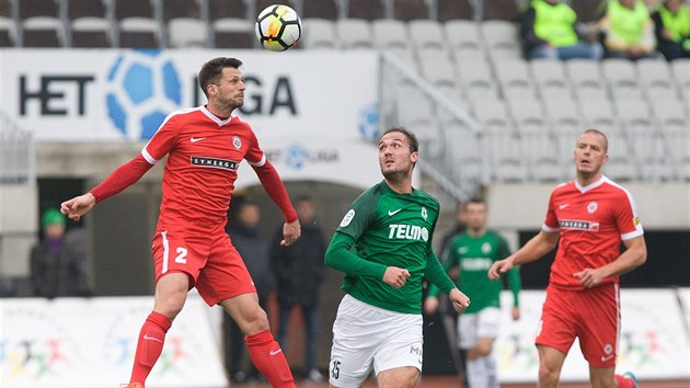 Jabloneck tonk Martin Doleal (v zelenm) pozoruje, co s mem provede brnnsk stoper Tadas Kijanskas.