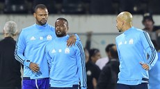 Patrice Evra (uprostřed) z Marseille v rozčílení nakopl fanouška, uklidňuje ho...