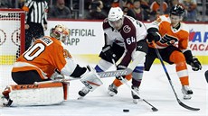 Michal Neuvirth hlídá branku Philadelphie ped Nailem Jakupovem z Colorada.