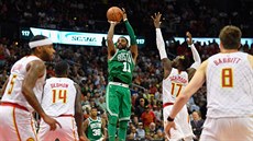 Kyrie Irving z Bostonu st�ílí na ko� Atlanty, o blok se sna�í Dennis Schröder.