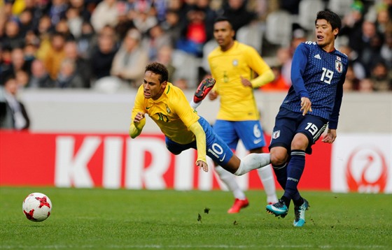 Brazilský útoník Neymar letí vzduchem po zákroku japonského soupee Hirokiho...