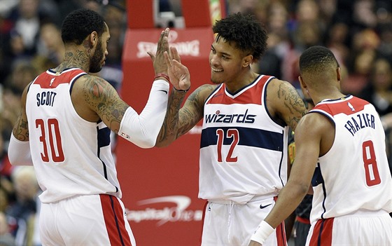 Mike Scott, Kelly Oubre Jr. a Tim Frazier (zleva) oslavují úspnou akci...