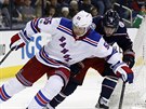 Nick Holden z New York Rangers má puk pod kontrolou, ale dotírá na nj Artmij...