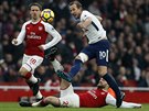 Harryho Kanea z Tottenhamu (v bílém) atakuje dvojice fotbalist Arsenalu, Nacho...