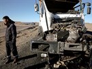 A man stands by a damaged truck after an accident en-route to China...