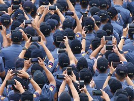 FOTOMÁNIE. Policisté poizují svými mobilními telefony fotky u píleitosti...