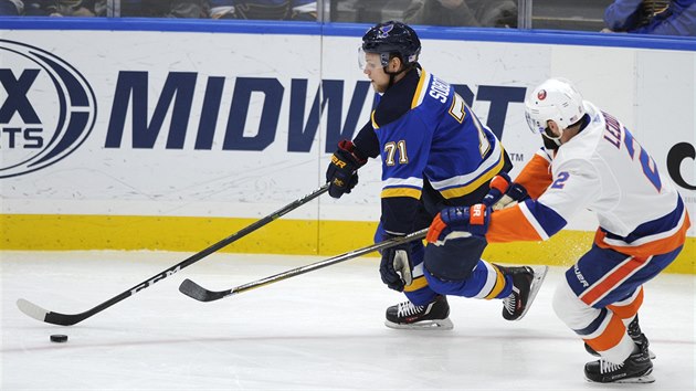 Vladimr Sobotka ze St. Louis ujd s pukem, sth ho Nick Leddy z New York Islanders.