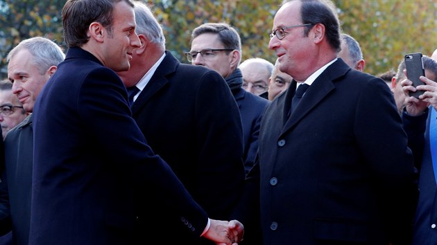 Prezident Emmanuel Macron se zdrav se svm pedchdcem Francoisem Hollandem ped ceremoni  u paskho stadionu Stade de France.