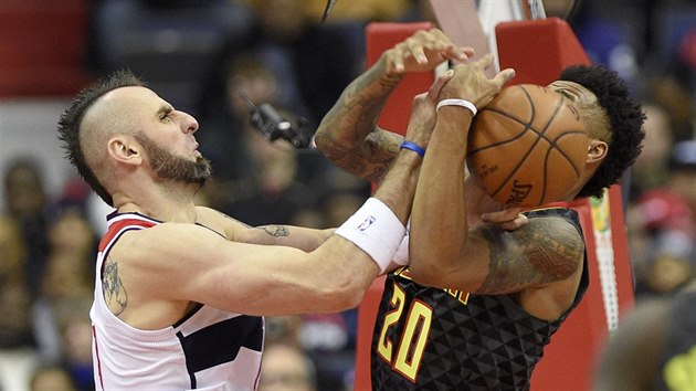 Marcin Gortat (vlevo) z Washingtonu na John Collins z Atlanty bojuj o m.