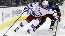 Nick Holden z New York Rangers má puk pod kontrolou, ale dotírá na nj Artmij...