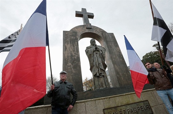 Skupina Francouzů demonstruje před sochou Jana Pavla II. v bretaňské vesničce...