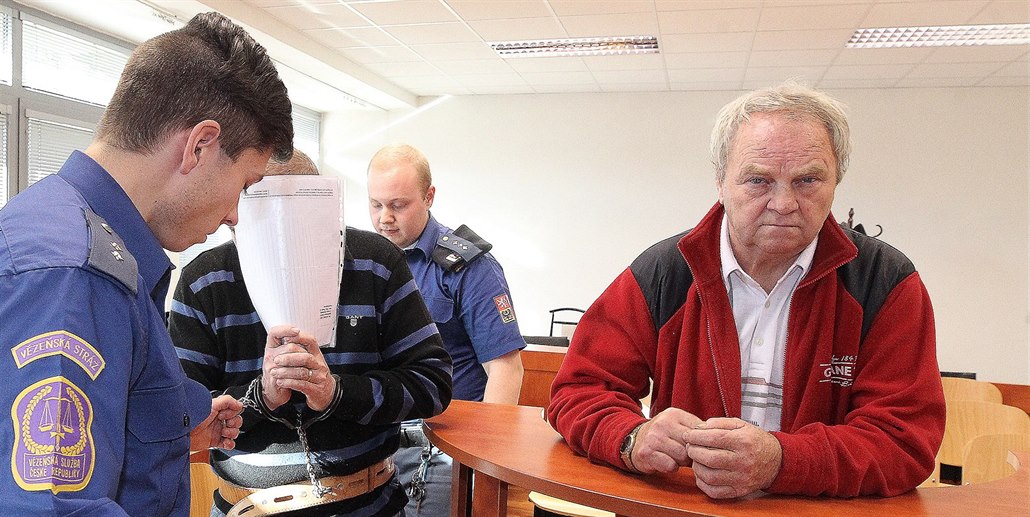 Dva ze čtyř obžalovaných - Petr Rázl, který si zakrývá obličej, a zcela vpravo...