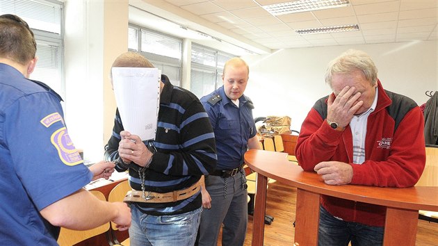 Dva ze čtyř obžalovaných - zleva Petr Rázl a Pavel Hanzálek si zakrývali obličeje.