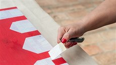 Pomocí malířské pásky vymezte prostor, který zůstane vybarvený červenou barvou.