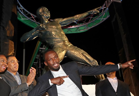 Usain Bolt pózuje ped svou sochou v Kingstonu.