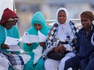 Zachránění migranti sedí v sicilském přístavu Messina poté, co je ze...