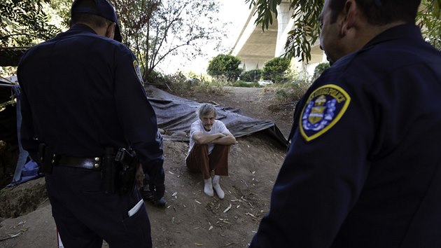 Policejní hlídka kontroluje bezdomovce žijícího pod mostem v San Diegu.