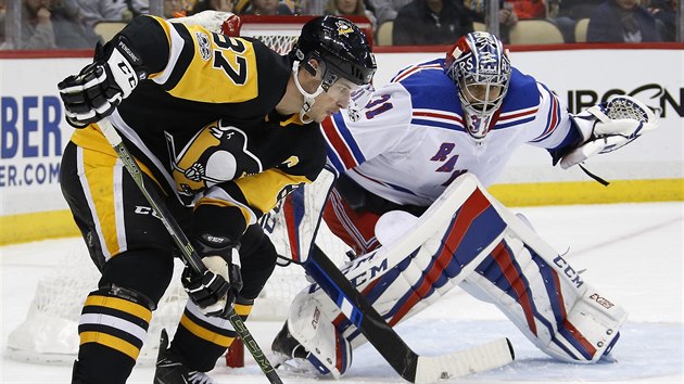 Brankář New York Rangers Ondřej Pavelec je ve střehu, před ním čaruje s pukem Sidney Crosby z Pittsburghu.