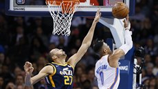 Russell Westbrook (vpravo) z Oklahoma City zakonuje pes Rudyho Goberta z...