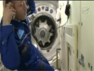 Otevřený poklop na ISS a za ním vstupní „dveře“ připojené lodi Sojuz.