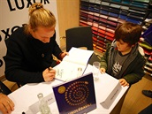 Tomáš Klus se podepisuje na křtu knížkodesky Ukolébavky.