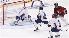 Kanadský hokejista Matt Frattin překonává korejského brankáře Matta Daltona.