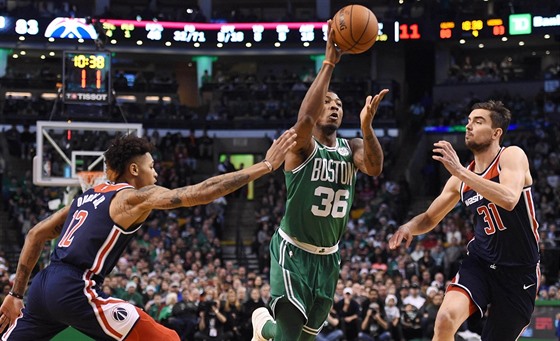 Marcus Smart (v zeleném) z Bostonu proniká mezi Kellym Oubrem (vlevo) a Tomáem...