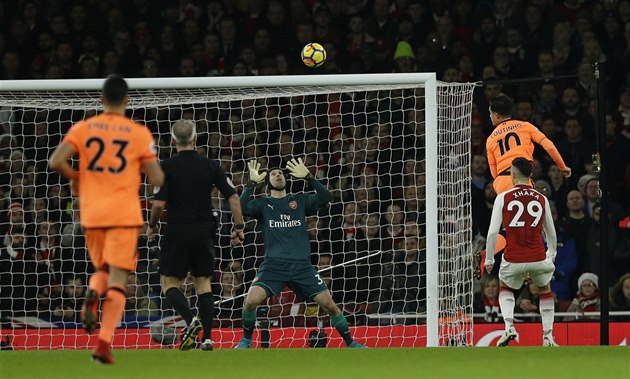 Philippe Coutinho (10) z Liverpoolu hlavi�kou p�ekonává Petra �echa z Arsenalu.