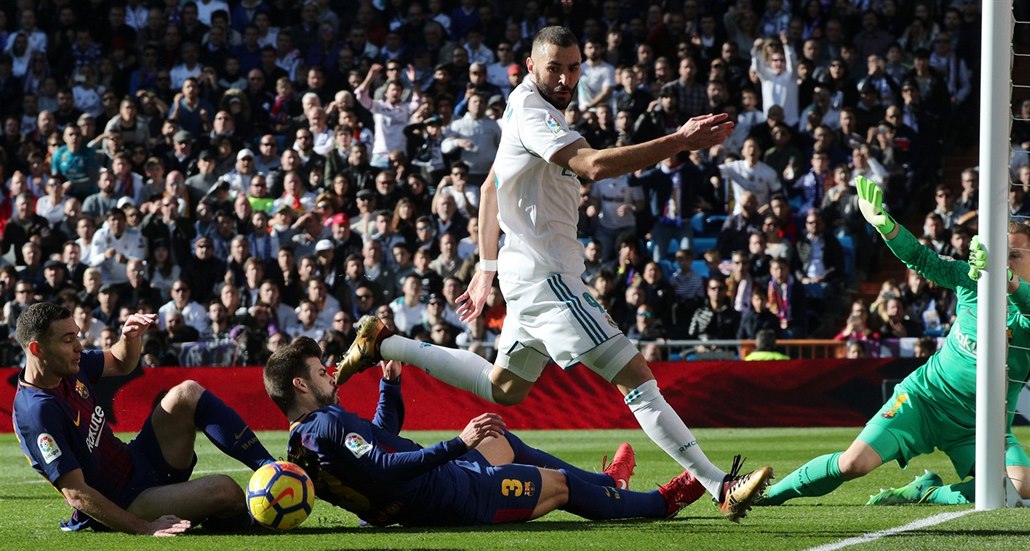Karim Benzema z Realu Madrid v �anci p�ed barcelonskou brankou. Brání ho Gerard...