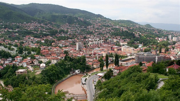 Sarajevo. Entitní hranice se táhne v lese nad zástavbou, poté klesá zvolna dolů a v oblasti posledního nejnižšího pahorku tvoří hranici ulice.