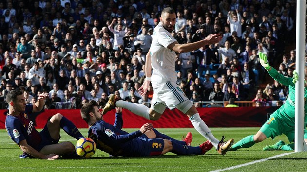 Karim Benzema z Realu Madrid v anci ped barcelonskou brankou. Brn ho Gerard Pique a Thomas Vermaelen