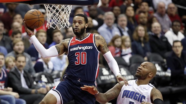 Mike Scott (vlevo) z Washingtonu let ke koi Orlanda kolem Marreeseho Speightse.