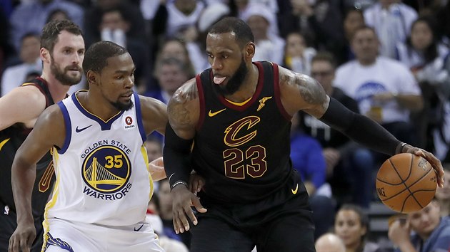 LeBron James (vpravo) z Clevelandu se tla do Kevina Duranta z Golden State.