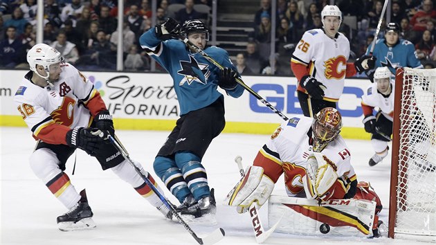 Brank Calgary David Rittich zastavuje steleck pokus Chrise Tierneyho ze San Jose (uprosted).