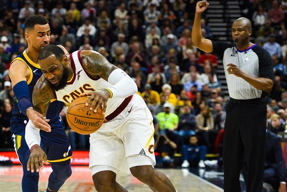 LeBron James (v bílém) z Clevelandu faulovaný Thabem Sefoloshou z Utahu.