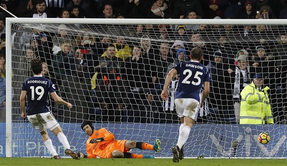 Jay Rodriguez z West Bromwiche (vlevo) pekonává z penalty brankáe Arsenalu...