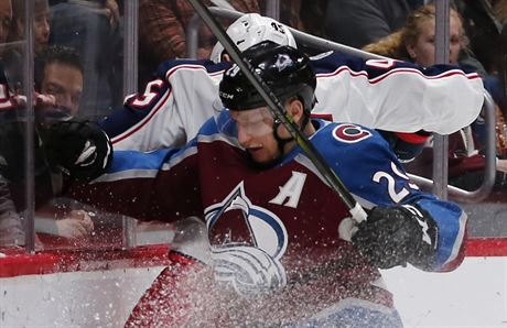 Nathan MacKinnon (v poped) z Colorada nar na mantinel Luke Sedlka z...