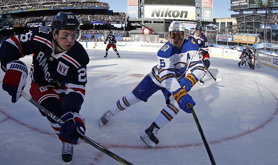 Po puku se natahují Jimmy Vesey (vlevo) z New York Rangers a Jack Eichel z...