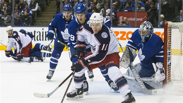 Matt Calvert z Columbusu si kryje puk ped Williamem Nylanderem z Toronta, ve stehu je brank Frederik Andersen.