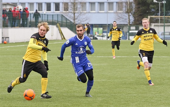 Martin Sladký z Olomouce (v modrém) napadá v pípravném utkání Petra iku z...