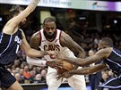 LeBron James (v bílém) z Clevelandu útoí kolem Evana Fourniera (vlevo) a...