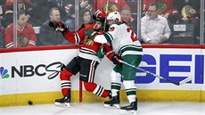 Vinnie Hinostroza (vlevo) z Chicaga a Ryan Suter z Minnestoy bojují u mantinelu...