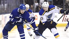 Auston Matthews (vlevo) z Toronta a Dmitrij Jakin ze St. Louis v souboji o puk.