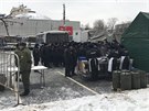Rutí policisté se shromaují u mobilní kuchyn v centru Moskvy. Za úkol mají...