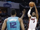 Wayne Ellington z Miami pálí na ko Charlotte, sleduje ho Dwight Howard.