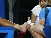 Korejec Čong Hjon se nechává ošetřit v semifinále Australian Open. Na levém...