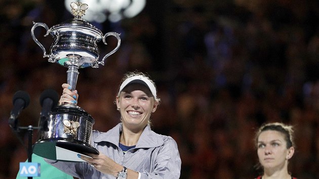 RADOST A ZKLAMÁNÍ. Caroline Wozniacká s trofejí pro šampionku Australian Open, za ní poražená finalistka Simona Halepová.