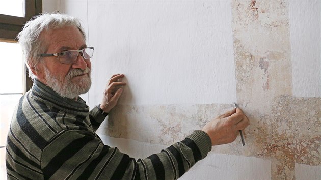 Restaurátor Petr Novotný pracuje na odkrytí nástěnné malby v rytířském sále.